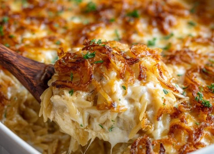 French Onion Chicken Orzo Casserole topped with melted cheese and herbs