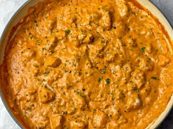 Delicious homemade butter chicken served with rice and garnished with cilantro