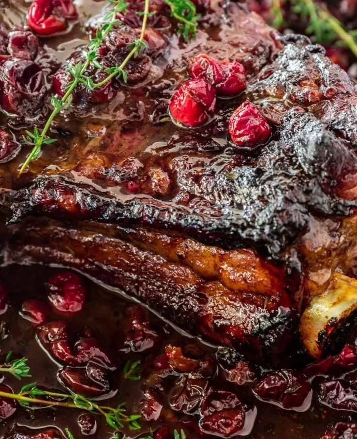 Juicy roast beef served with cranberry sauce and balsamic reduction on a plate.