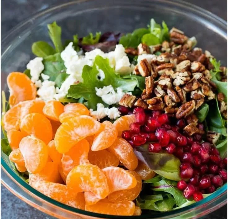 A colorful winter salad featuring seasonal greens, fruits, and nuts for a nutritious meal.