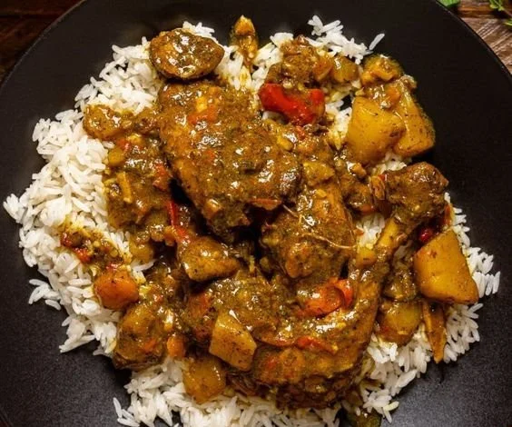Delicious plate of Authentic Jamaican Curry Chicken served with rice and vegetables.