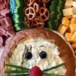 Festively arranged Easter charcuterie board with colorful cheeses and treats.